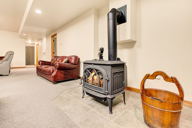 living area with a wood stove, recessed lighting, baseboards, and light carpet