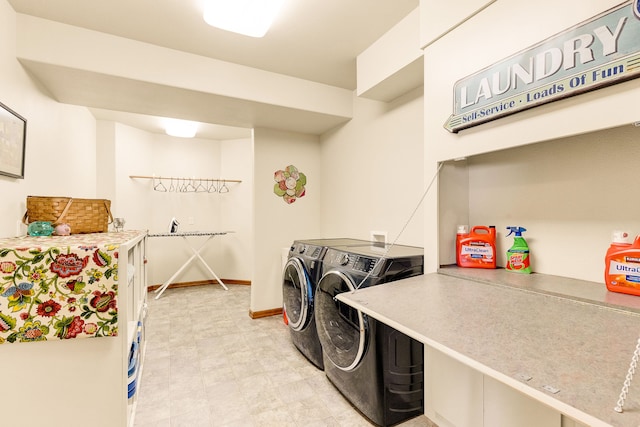 washroom with separate washer and dryer, light floors, and baseboards