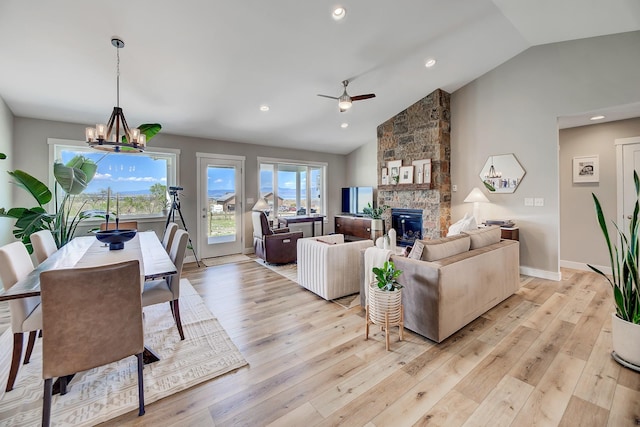 living room featuring a fireplace, ceiling fan, light wood finished floors, a chandelier, and recessed lighting