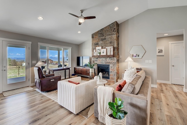 living area with vaulted ceiling, light wood-style flooring, ceiling fan, a fireplace, and recessed lighting