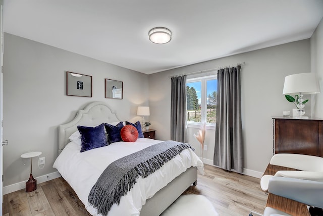 bedroom with light wood-style floors and baseboards