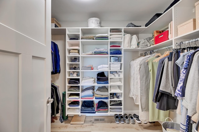 walk in closet with wood finished floors