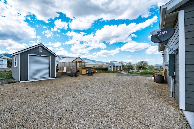 view of yard with an exterior structure, an outdoor structure, fence, and a mountain view