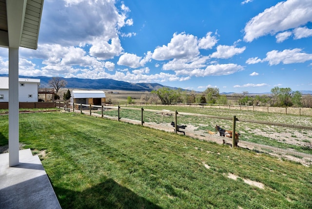 view of yard with a view of rural / pastoral area, a mountain view, and an outbuilding