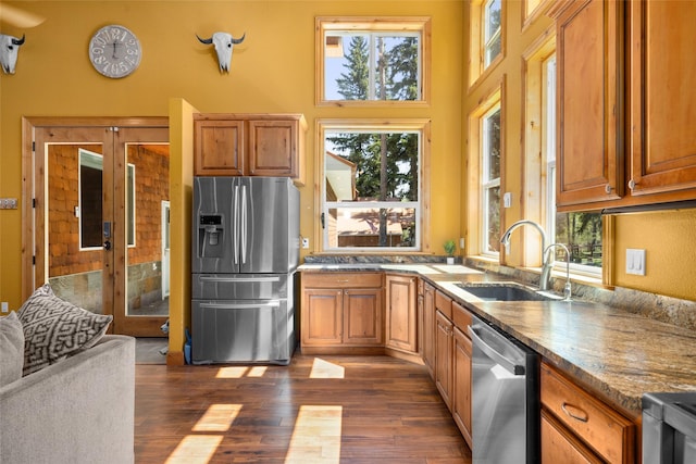 1492 Mcmannamy Draw, Kalispell, MT 59901 - kitchen with stainless steel appliances, plenty of natural light, dark wood-type flooring, and brown cabinetry