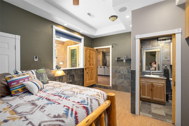 1492 Mcmannamy Draw, Kalispell, MT 59901 - bedroom featuring tile walls, recessed lighting, a tray ceiling, and ensuite bath