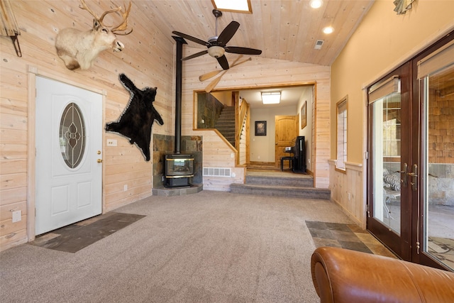 1492 Mcmannamy Draw, Kalispell, MT 59901 - carpeted entryway featuring wood walls, wood ceiling, lofted ceiling, stairs, and a wood stove