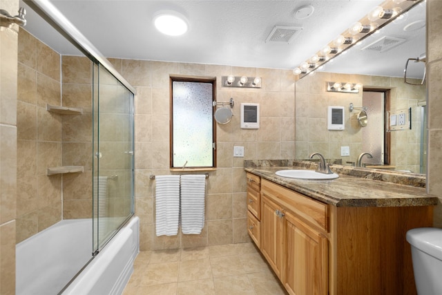 1492 Mcmannamy Draw, Kalispell, MT 59901 - full bath featuring vanity, shower / bath combination with glass door, tile patterned flooring, and tile walls
