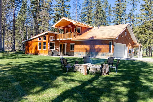 1492 Mcmannamy Draw, Kalispell, MT 59901 - back of property featuring a balcony, a lawn, a garage, and driveway