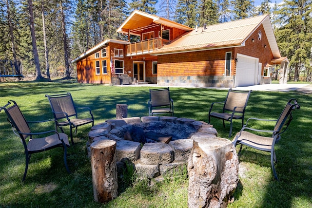 1492 Mcmannamy Draw, Kalispell, MT 59901 - rear view of house with a fire pit, a lawn, a garage, and a metal roof