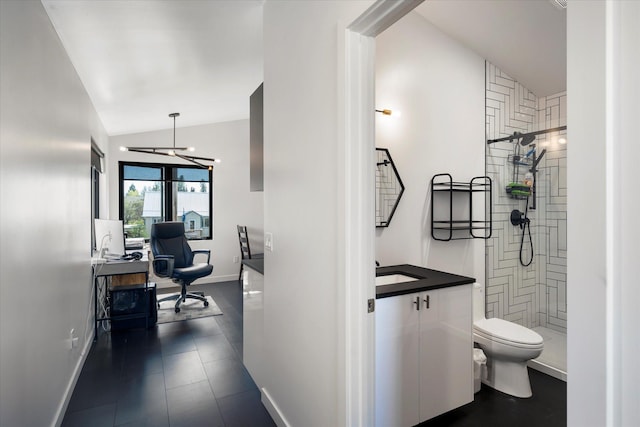 772 Denver St Unit A & B, Whitefish, MT 59937 - bathroom featuring baseboards, toilet, tiled shower, vanity, and vaulted ceiling