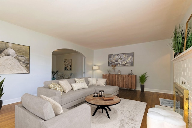 300 Evans Ave, Missoula, MT 59801 - living area with arched walkways, wood finished floors, a glass covered fireplace, and baseboards