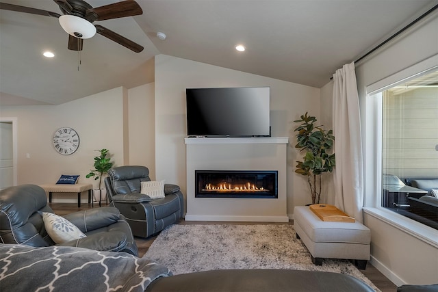 517 Raven Ln, Kalispell, MT 59901 - living area with lofted ceiling, a glass covered fireplace, wood finished floors, a ceiling fan, and recessed lighting