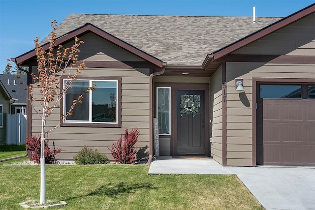 517 Raven Ln, Kalispell, MT 59901 - view of exterior entry with a shingled roof, a lawn, and a garage