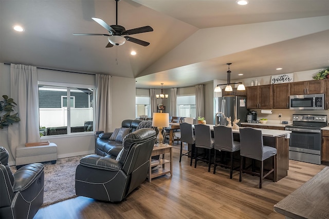 517 Raven Ln, Kalispell, MT 59901 - living room featuring vaulted ceiling, light wood finished floors, a ceiling fan, a chandelier, and recessed lighting