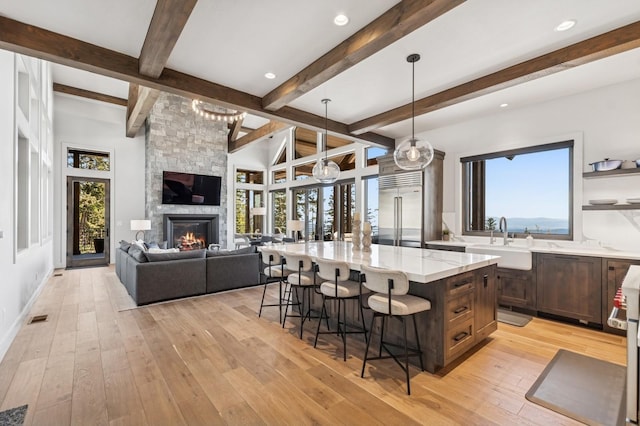 145 Elk Highlands Dr, Whitefish, MT 59937 - kitchen with built in fridge, a sink, a breakfast bar, a spacious island, and light stone counters