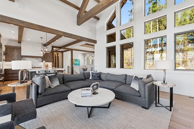 145 Elk Highlands Dr, Whitefish, MT 59937 - living room with a chandelier, light wood-style floors, beamed ceiling, a high ceiling, and baseboards