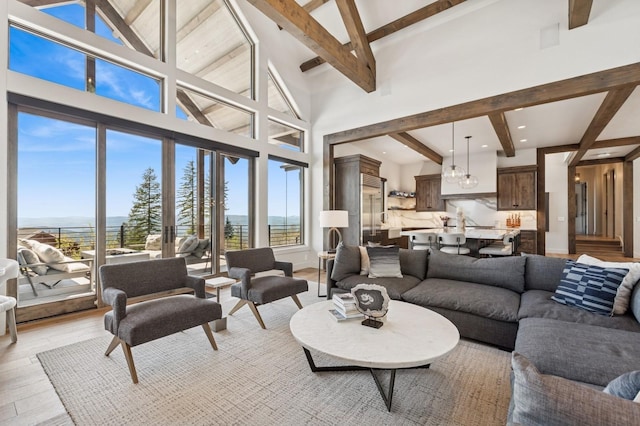 145 Elk Highlands Dr, Whitefish, MT 59937 - living room with beamed ceiling, healthy amount of natural light, light wood-style floors, a towering ceiling, and a water view