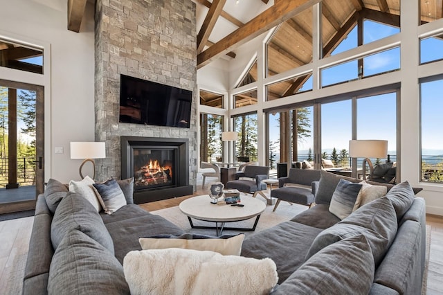 145 Elk Highlands Dr, Whitefish, MT 59937 - living area with wood finished floors, beam ceiling, a fireplace, and high vaulted ceiling
