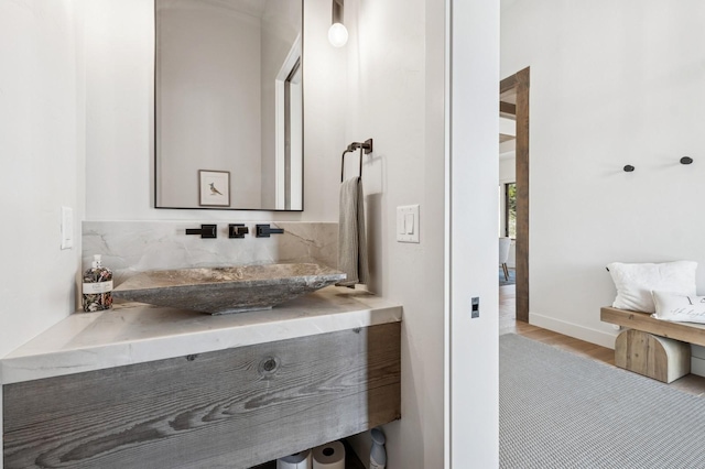 145 Elk Highlands Dr, Whitefish, MT 59937 - bathroom with wood finished floors, decorative backsplash, baseboards, and vanity