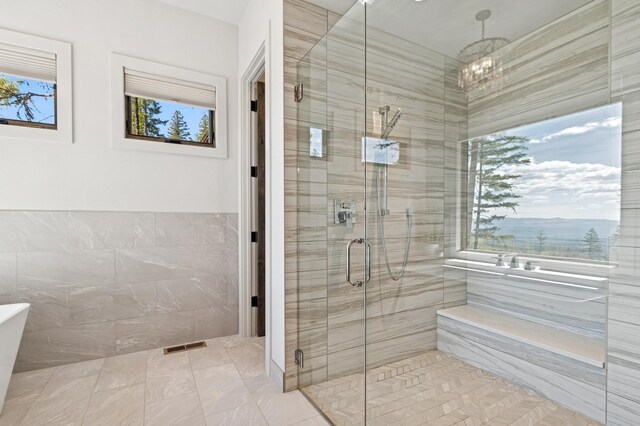 145 Elk Highlands Dr, Whitefish, MT 59937 - bathroom with a stall shower, a chandelier, a freestanding bath, and tile walls