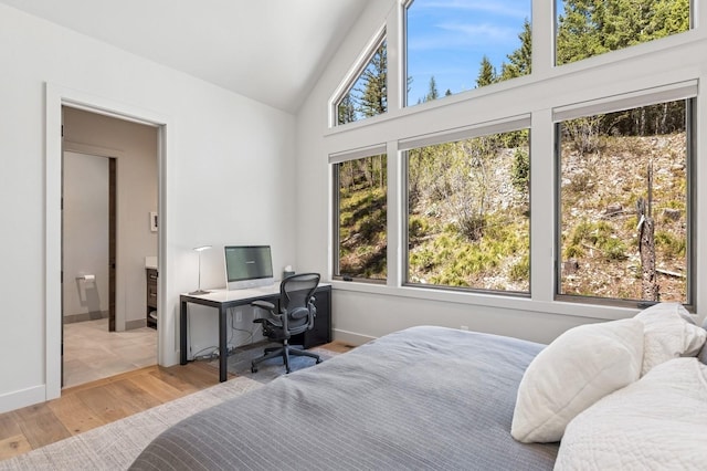 145 Elk Highlands Dr, Whitefish, MT 59937 - bedroom featuring wood finished floors, high vaulted ceiling, a desk, and baseboards