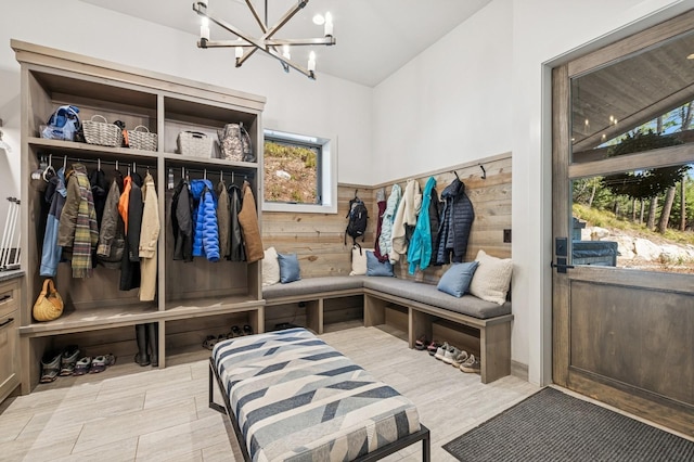 145 Elk Highlands Dr, Whitefish, MT 59937 - mudroom with a chandelier, lofted ceiling, wood finished floors, and wooden walls