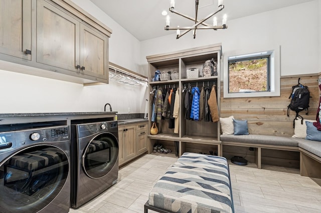 145 Elk Highlands Dr, Whitefish, MT 59937 - washroom with cabinet space, washer and clothes dryer, a chandelier, and wood walls