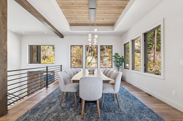 145 Elk Highlands Dr, Whitefish, MT 59937 - dining area featuring wooden ceiling, healthy amount of natural light, a chandelier, a tray ceiling, and wood finished floors