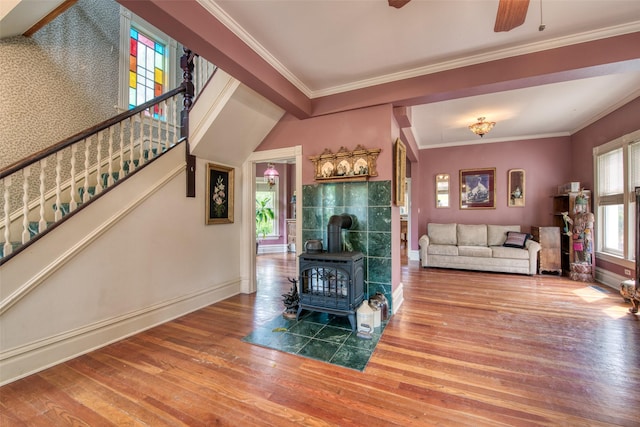 living room featuring wood finished floors, baseboards, stairs, and ornamental molding