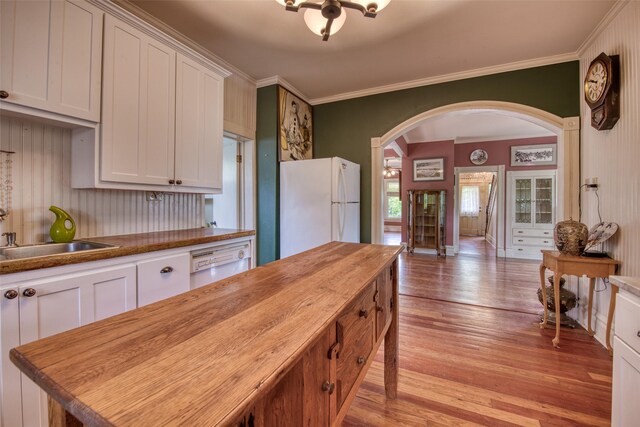 kitchen with white appliances, wood counters, arched walkways, a sink, and light wood finished floors