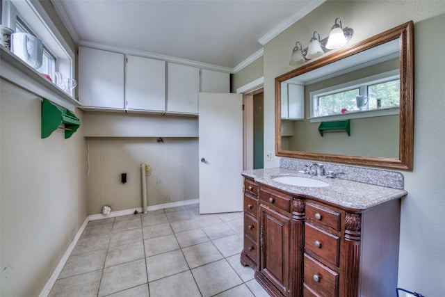 bathroom with tile patterned floors, vanity, ornamental molding, and baseboards