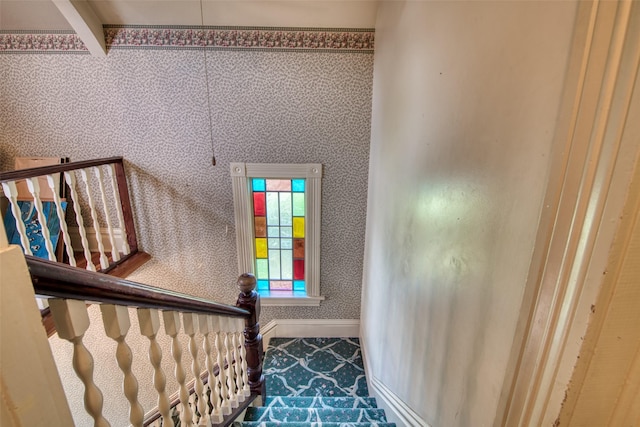stairway featuring wallpapered walls and baseboards
