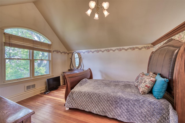 bedroom with vaulted ceiling and hardwood / wood-style flooring