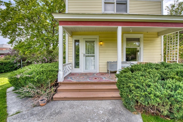 view of exterior entry featuring covered porch