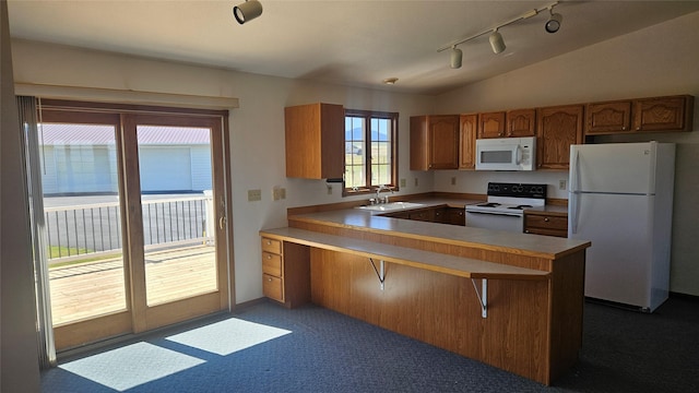 2315 Cattle Dr, East Helena, MT 59635 - kitchen featuring white appliances, rail lighting, a sink, brown cabinets, and a peninsula