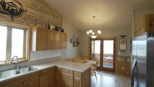 1723 W Springcreek Rd, Kalispell, MT 59901 - kitchen featuring freestanding refrigerator, lofted ceiling, a sink, wood walls, and a peninsula