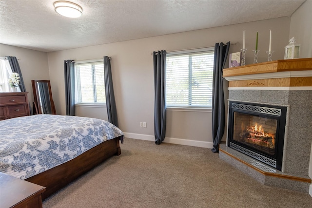 31 Aspen Ct, Kalispell, MT 59901 - carpeted bedroom featuring a textured ceiling, baseboards, and a tiled fireplace