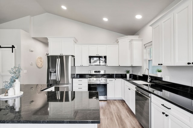 286 Ordway Dr, Florence, MT 59833 - kitchen featuring appliances with stainless steel finishes, a sink, vaulted ceiling, white cabinetry, and light wood finished floors