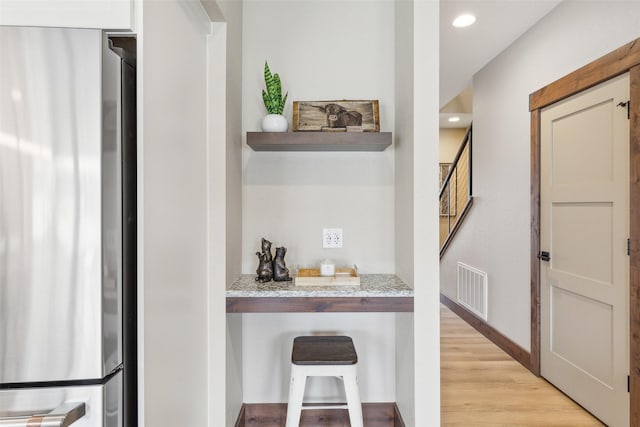 bar featuring freestanding refrigerator, light wood-style flooring, and recessed lighting