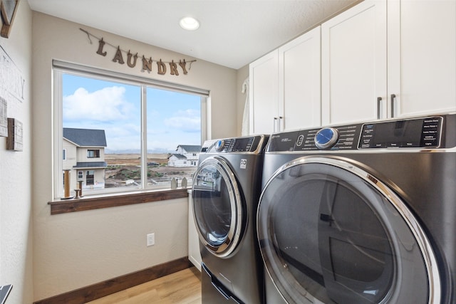 washroom featuring washer and clothes dryer, cabinet space, light wood-style flooring, baseboards, and recessed lighting