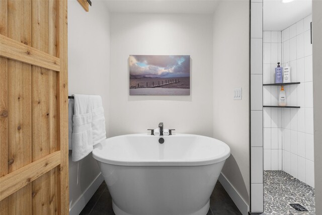 full bath featuring tiled shower, baseboards, and a soaking tub