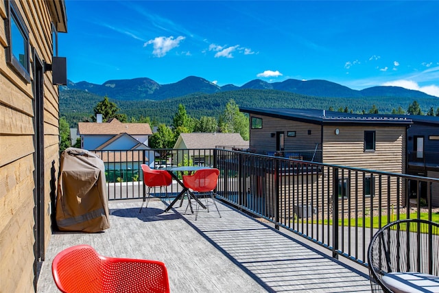 view of patio / terrace featuring a balcony, a mountain view, and a grill