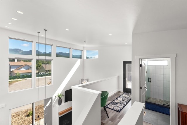hallway with recessed lighting, wood finished floors, baseboards, and a mountain view