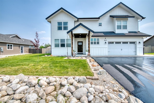 view of front of house with board and batten siding, a garage, and asphalt driveway