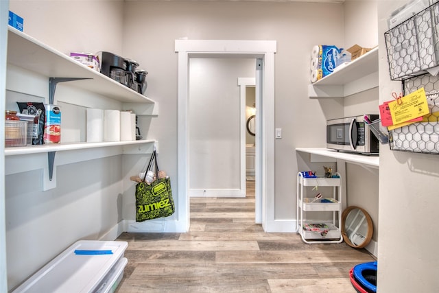 laundry room featuring wood finished floors and baseboards