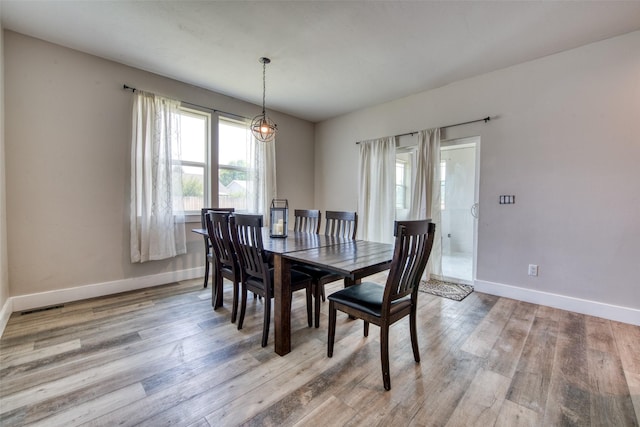 dining room featuring baseboards and light wood-type flooring