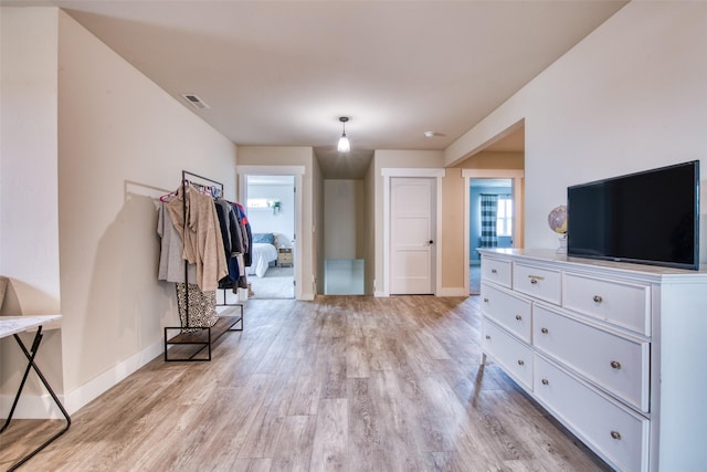 foyer featuring baseboards, plenty of natural light, and light wood finished floors