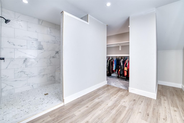 walk in closet with wood finished floors