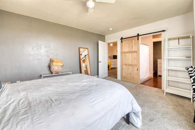 bedroom featuring a barn door, carpet flooring, and ceiling fan